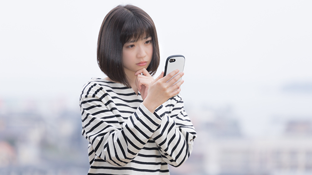 電話占いで違う鑑定結果に悩んでいる女性のイメージ画像